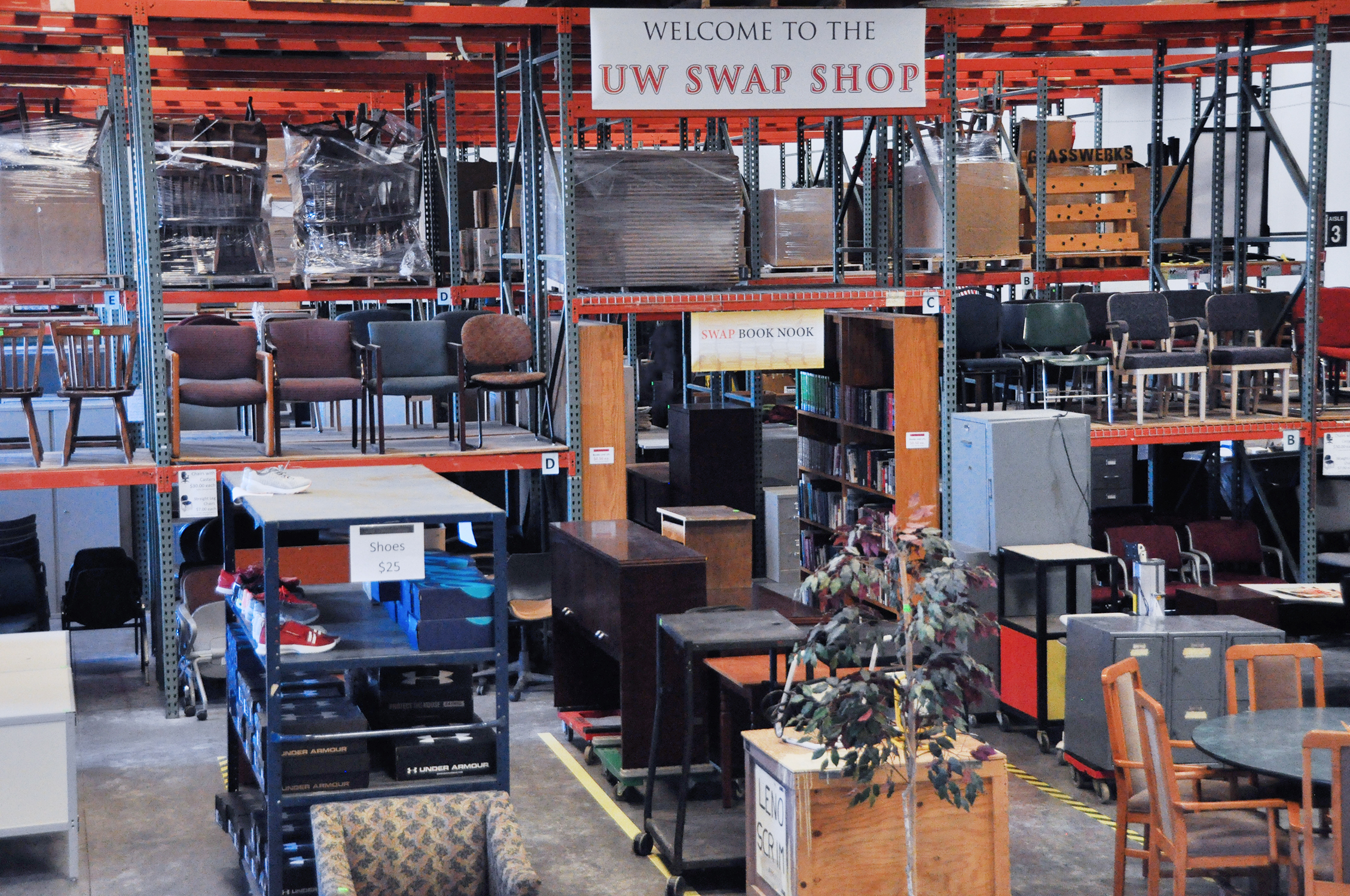 Photo of a warehouse with pallet racking and rows of furniture on the ground